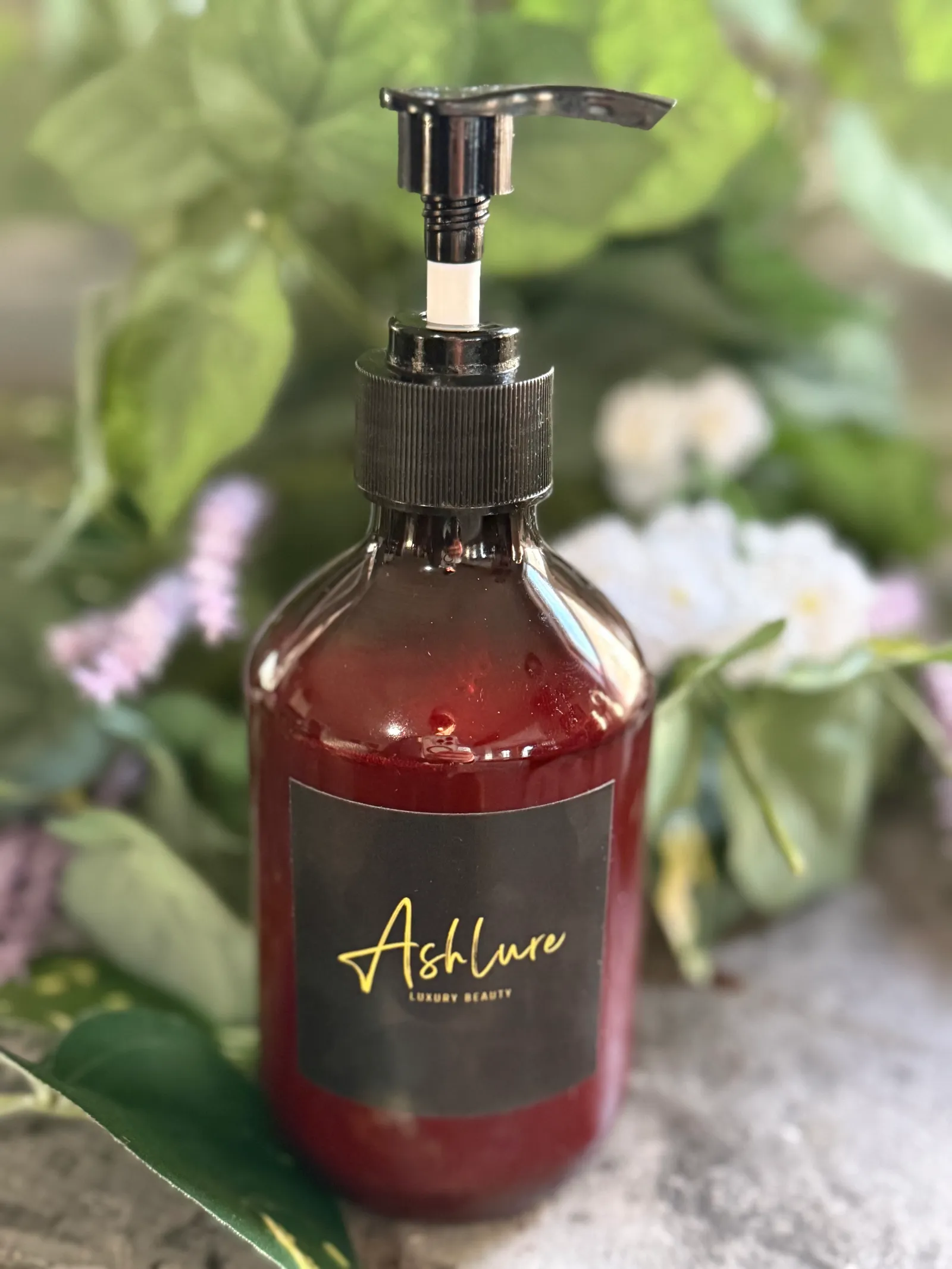It Girl Glow Oil in an amber pump bottle with the gold Ashlure label