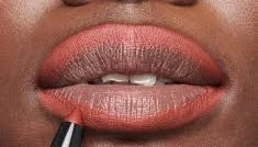Lips wearing the Peachy Glow lip combo: a warm peach-coral lip with a softly defined liner