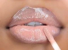 Lips wearing the White Fire lip combo: a sheer, glassy nude with a high-shine finish